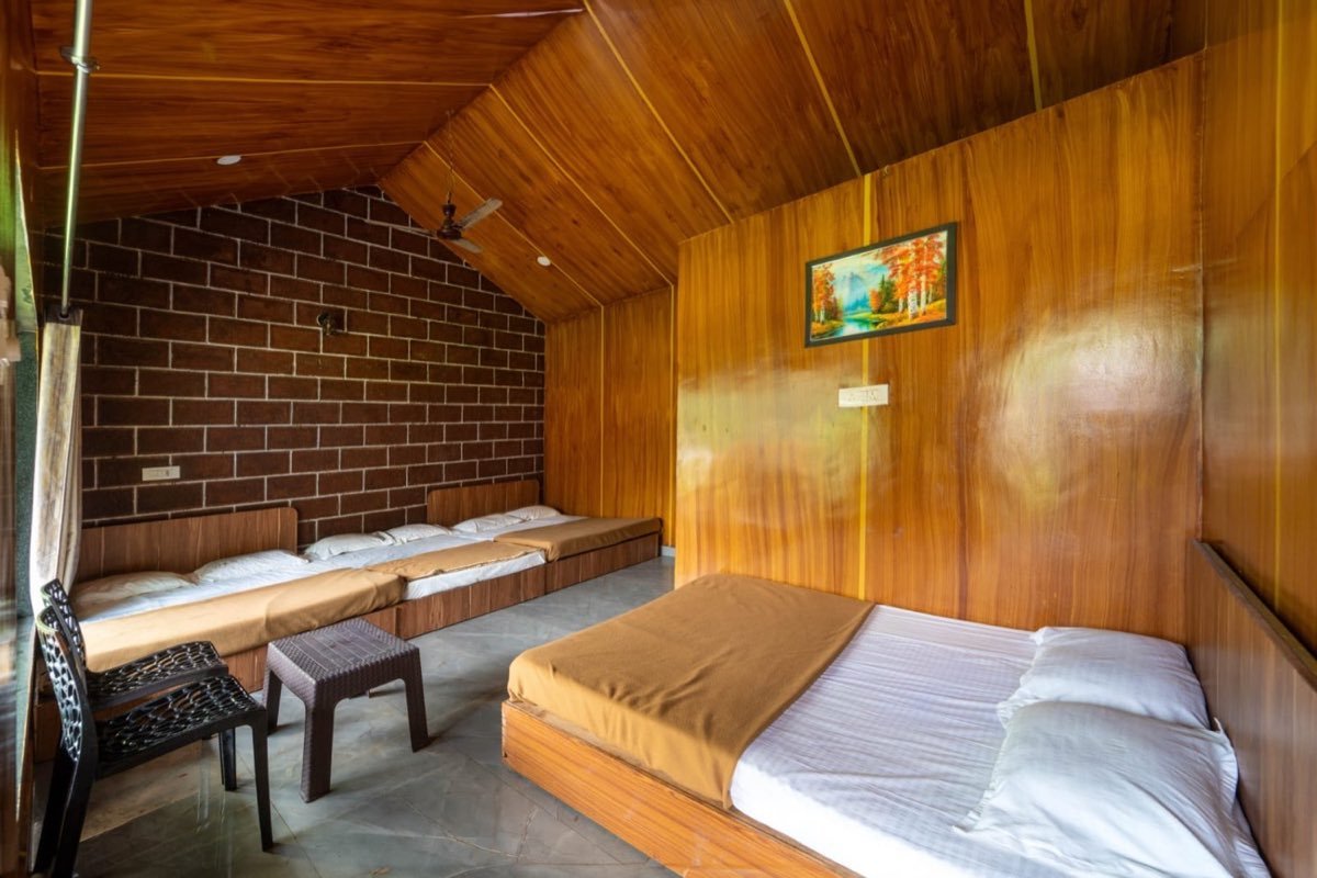 Wooden A-shape cottage interior with brick wall and cozy beds