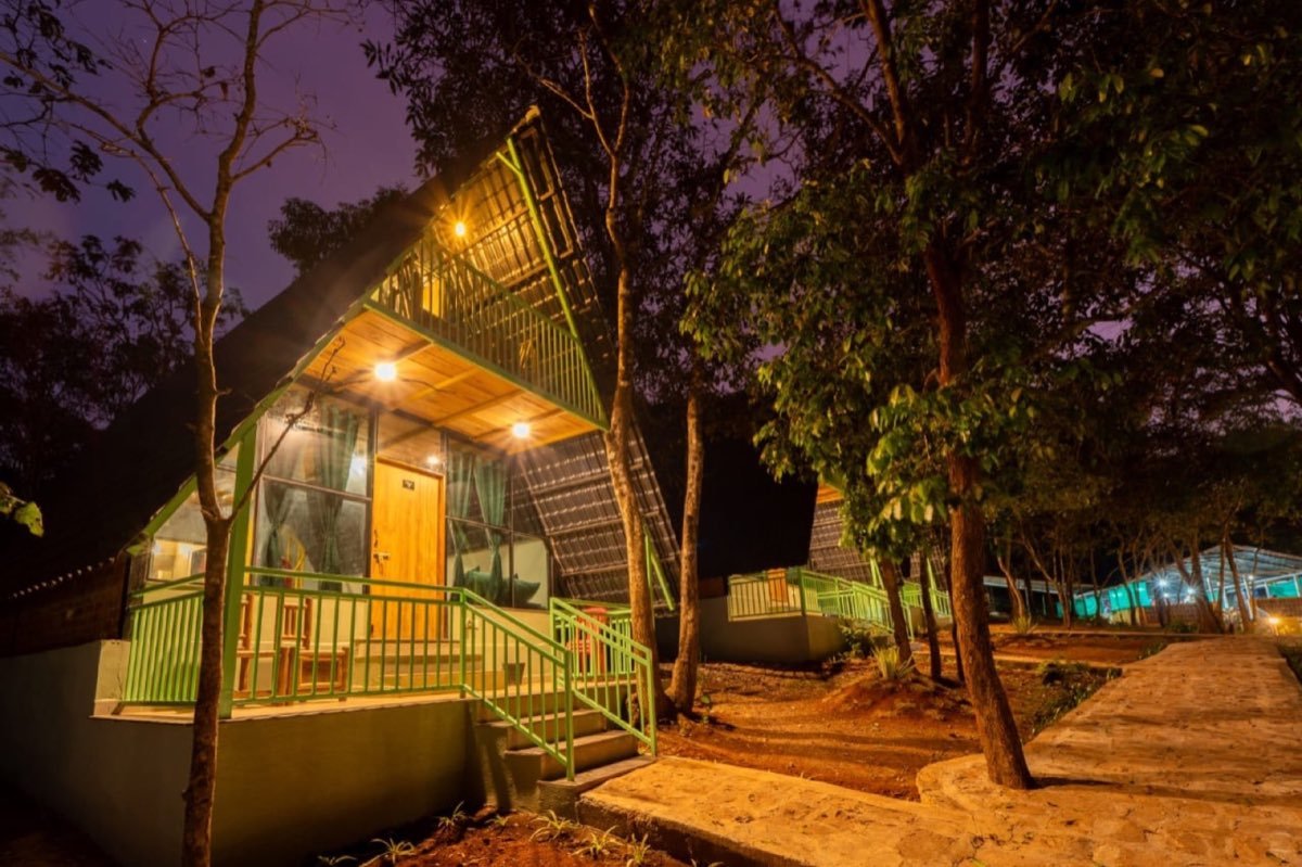 Duplex triangle A-frame cottage with green trim lit up at night