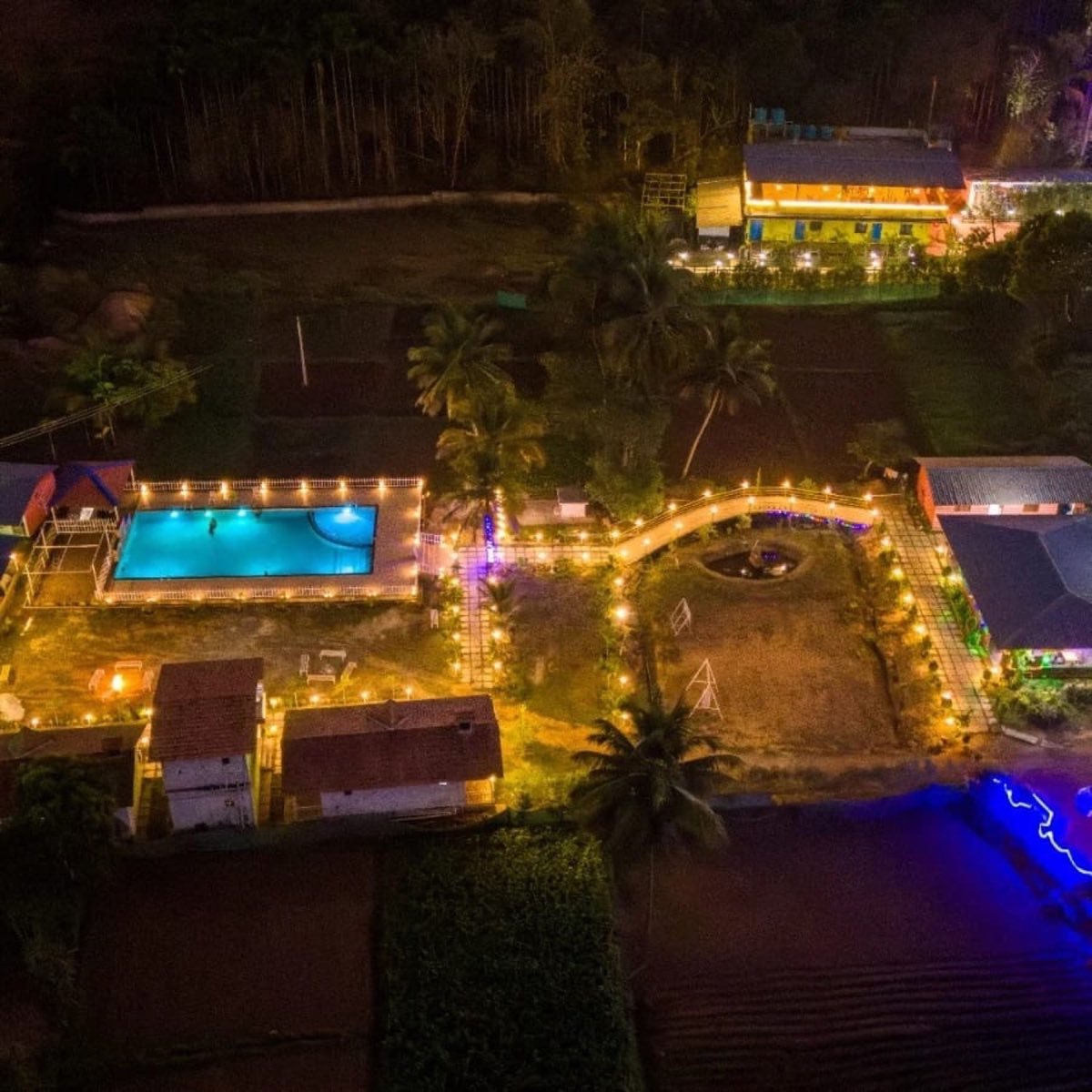 Dandeli resort glowing at night around the pool