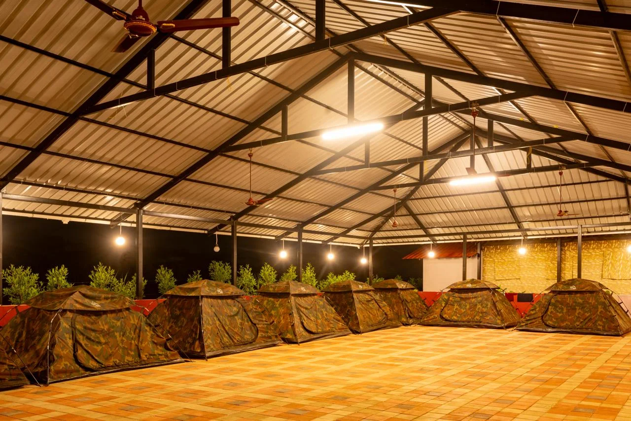 Camping tents under a covered pavilion at night