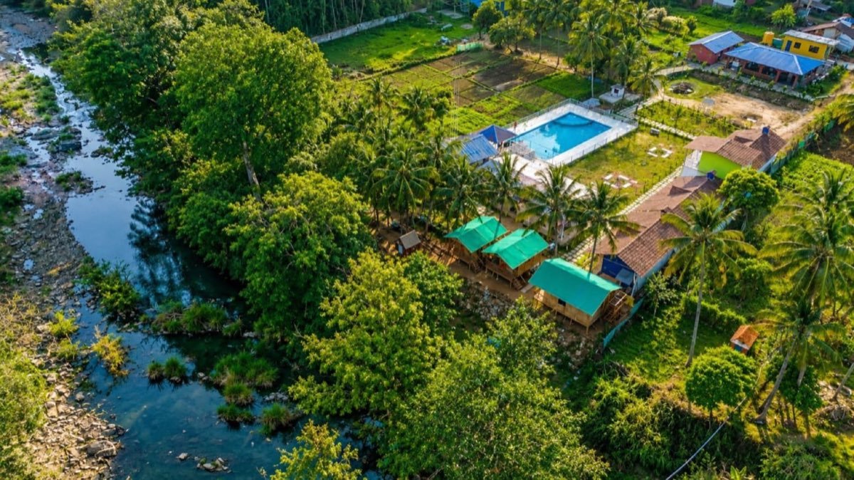Aerial view of the riverside resort, pool and tents
